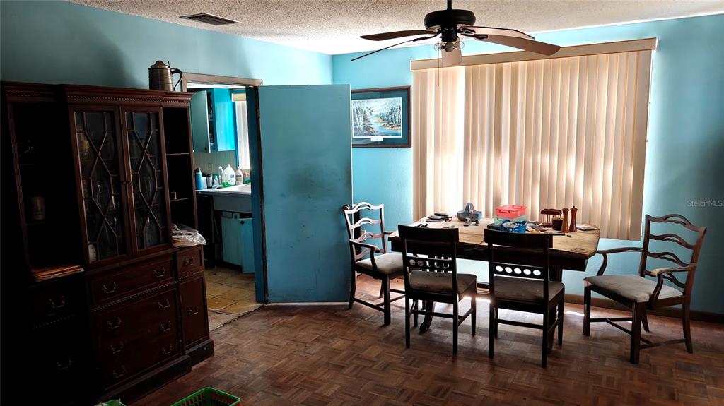 A dining room features a wooden table, four chairs, a hutch, and light blue walls — 1024 AVON AVENUE, LAKELAND, FL