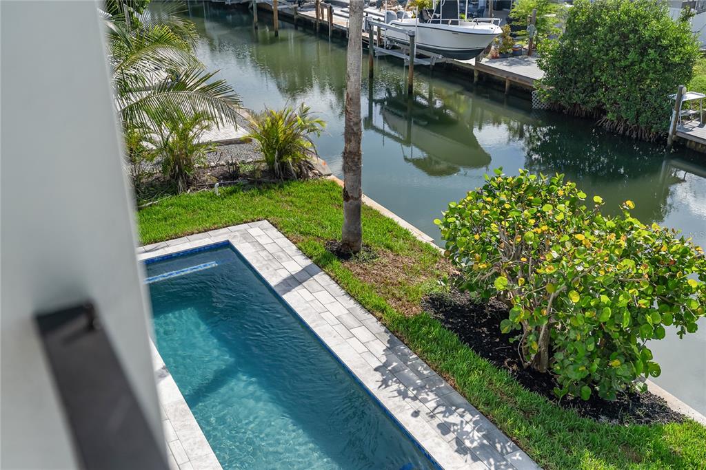 An elevated view of a small rectangular swimming pool next to a canal with boats — 530 DE NARVAEZ DRIVE, LONGBOAT KEY, FL