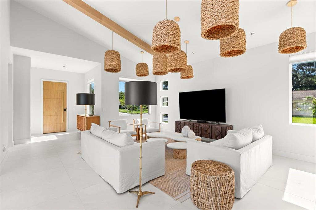 A bright living room features white sofas, woven pendant lights, and a large television — 5150 DARTMOUTH AVENUE N, ST PETERSBURG, FL