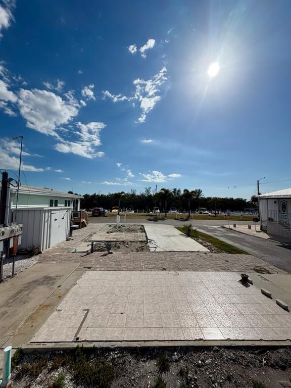 A vacant residential lot features a tiled patio area and a small storage shed — 10315 CORTEZ ROAD W UNIT 4-4, BRADENTON, FL