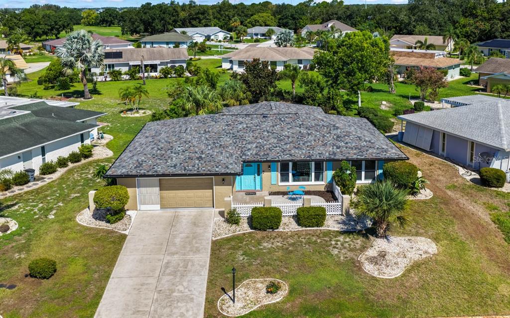 An aerial view of a single-story house with a shingled roof and a concrete driveway — 234 AMESBURY CIRCLE, SUN CITY CENTER, FL