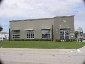 A paved parking lot between two commercial buildings with several parked vehicles and a dumpster — 145 RONNING WAY, LONGWOOD, FL