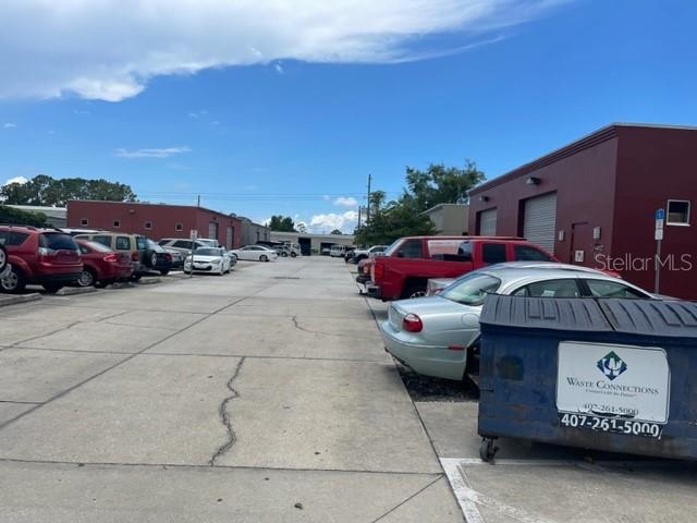 A gray commercial building exterior features two roll-up garage doors and a parked white SUV — 145 RONNING WAY, LONGWOOD, FL