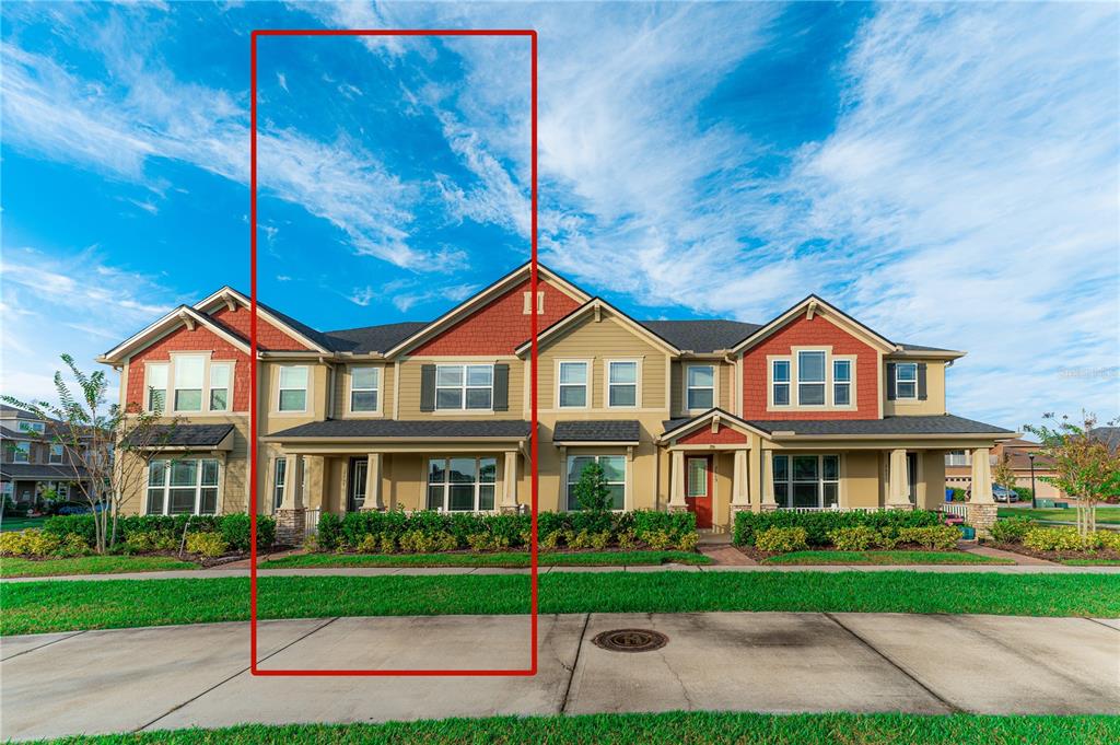 A multi-unit townhouse building features tan and red siding with a front porch and lawn — 2617 GIARDINO LOOP, KISSIMMEE, FL