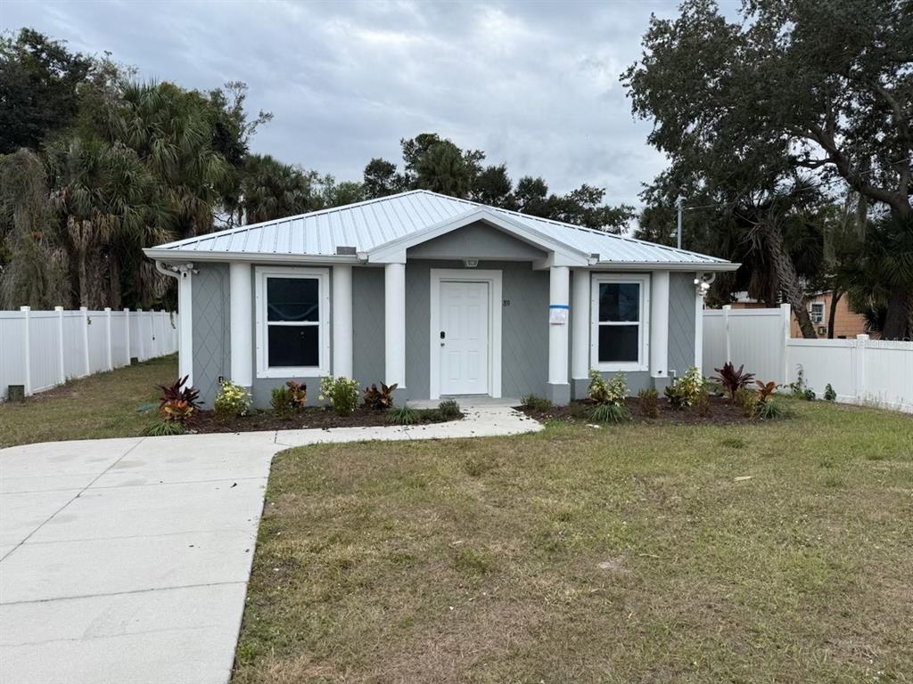 A gray, single-story house with a white metal roof and four front pillars — 89 W IMOGENE STREET, ARCADIA, FL