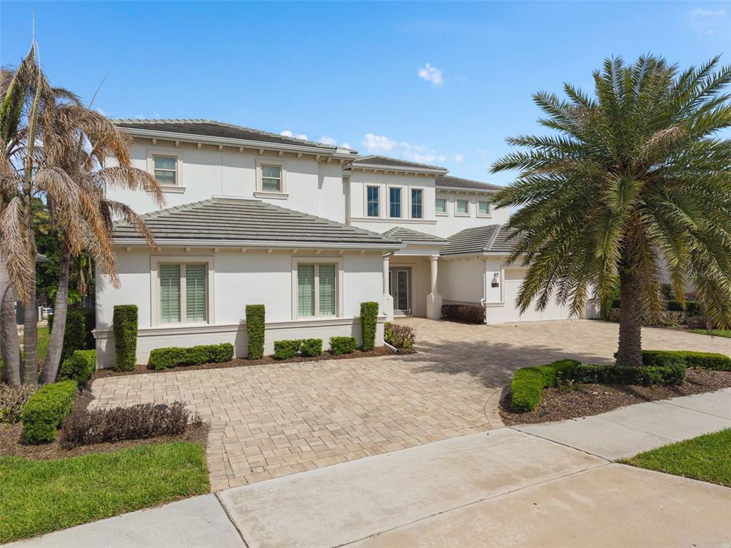 An aerial view shows a two-story house with a paved driveway beside a lake — 15522 SHOREBIRD LANE, WINTER GARDEN, FL