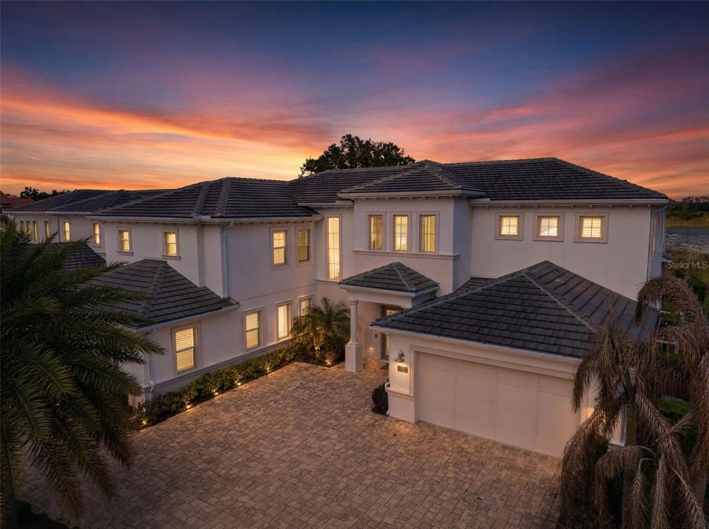 A two-story white stucco house with a tiled roof and a paved driveway — 15522 SHOREBIRD LANE, WINTER GARDEN, FL