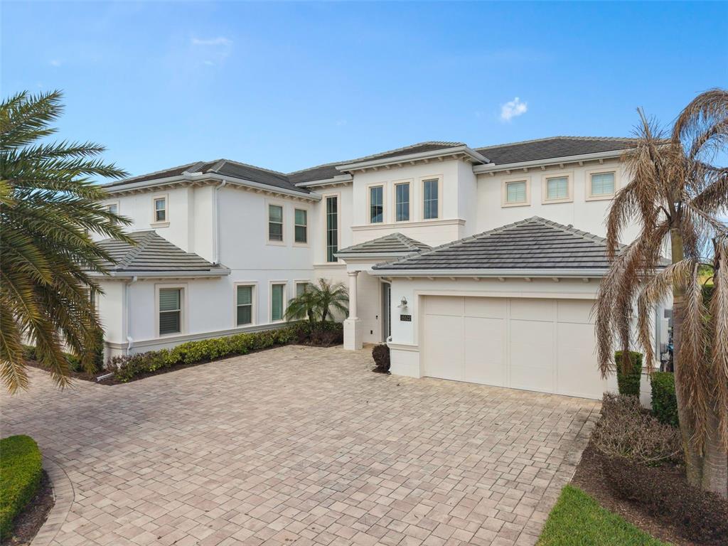 A screened-in pool and spa overlook a lake at sunset — 15522 SHOREBIRD LANE, WINTER GARDEN, FL