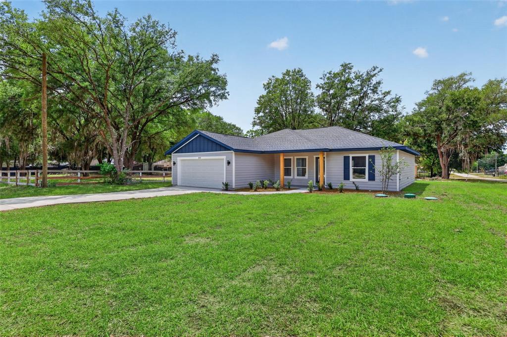 A single-story house with gray siding, a blue gable, and a two-car garage — 13932 SW 104TH LANE, DUNNELLON, FL