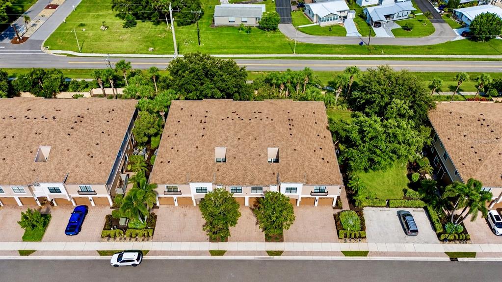An aerial view shows two multi-story townhouses with brown roofs and attached garages — 4033 OVERTURE CIRCLE, BRADENTON, FL