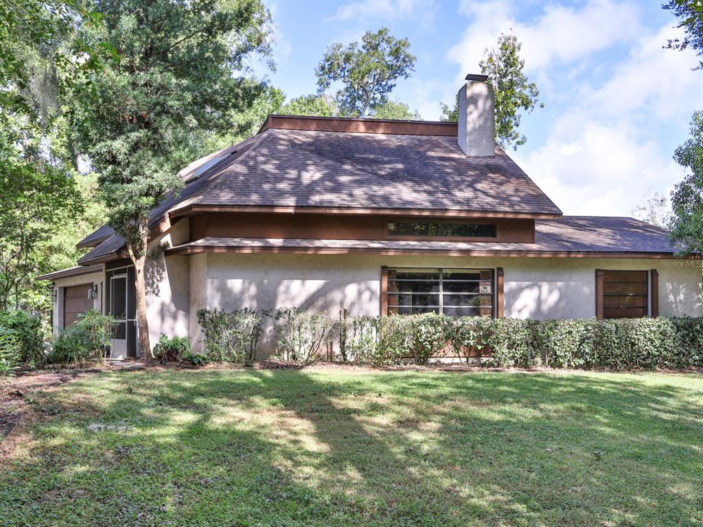 A two-story house with a stucco exterior, a shingled roof, and a stone chimney — 6103 SKY FLOWER COURT, BARTOW, FL