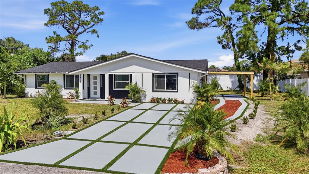 A single-story house with a white exterior, a modern front door, and a paved driveway — 848 OLYMPIA ROAD, VENICE, FL