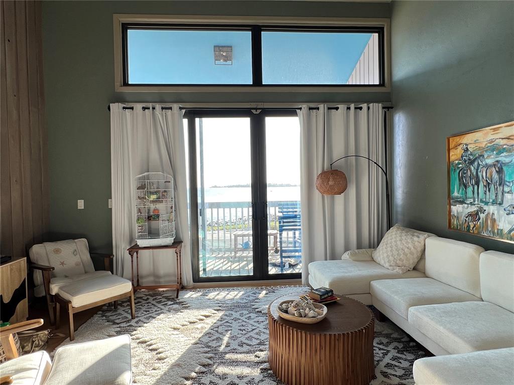 A living room features a white sectional, a round coffee table, and sliding glass doors — 850 3RD STREET UNIT 2, CEDAR KEY, FL