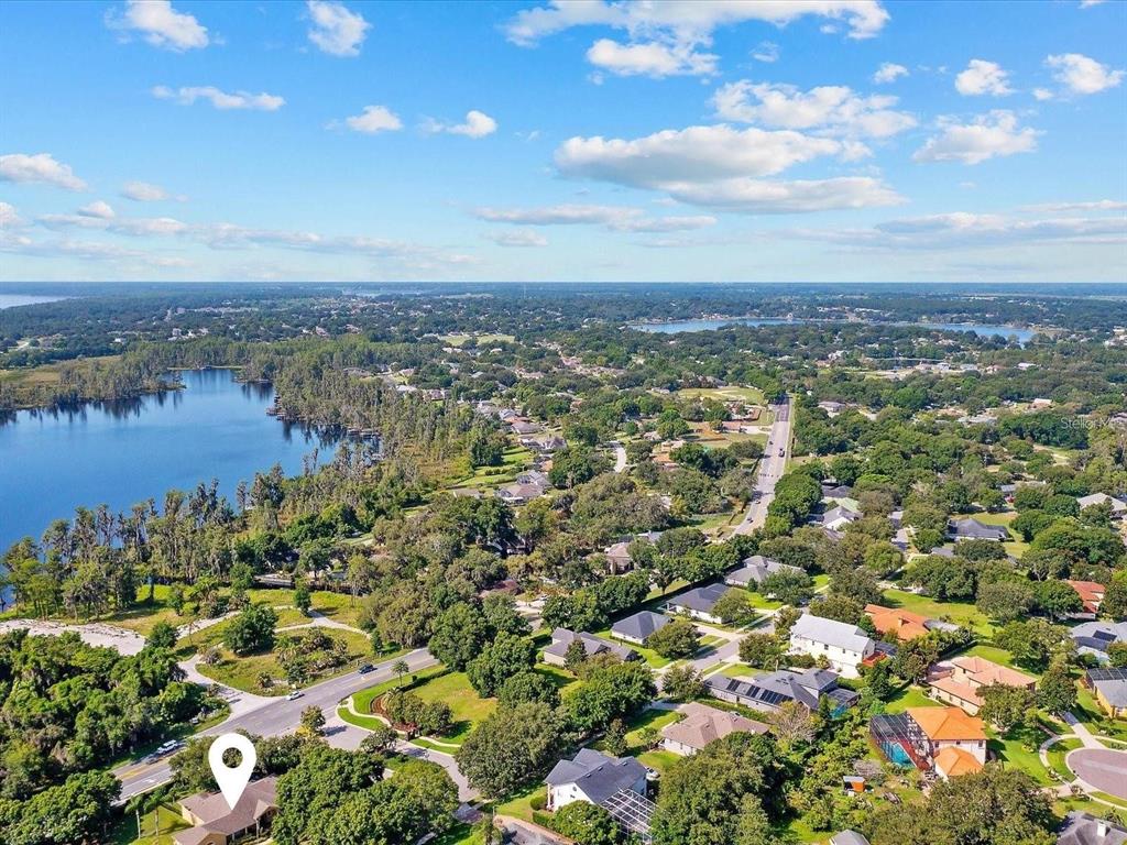 An aerial view shows a residential neighborhood situated next to a large lake — 11812 OSPREY POINTE BOULEVARD, CLERMONT, FL