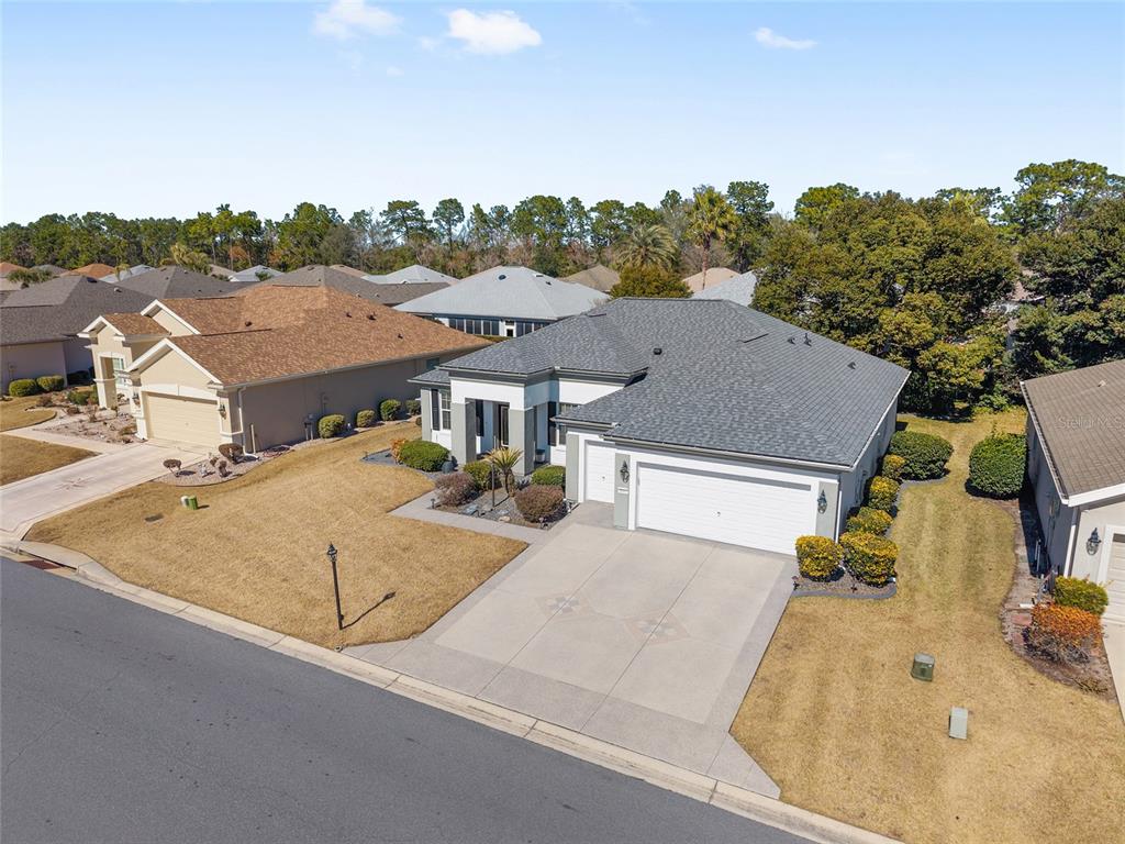 An aerial view of a suburban house with a gray roof and a concrete driveway — 9003 SE 118TH LANE, SUMMERFIELD, FL