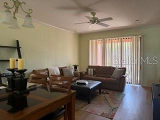 A living room features a brown leather sofa, a dark ottoman, and a dining area — 147 SHELL FALLS DRIVE, APOLLO BEACH, FL