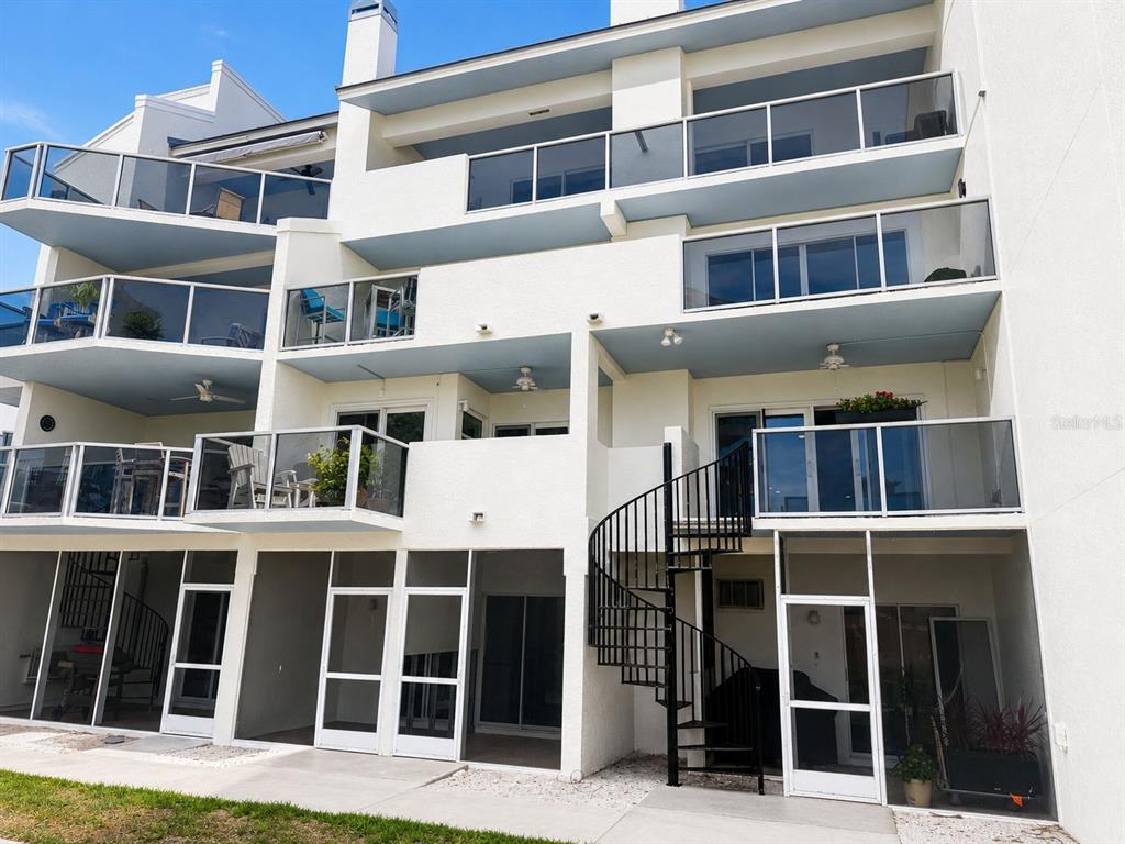 A concrete staircase leads into shallow water next to a wooden dock and railing — 1100 PINELLAS BAYWAY S UNIT G2, TIERRA VERDE, FL