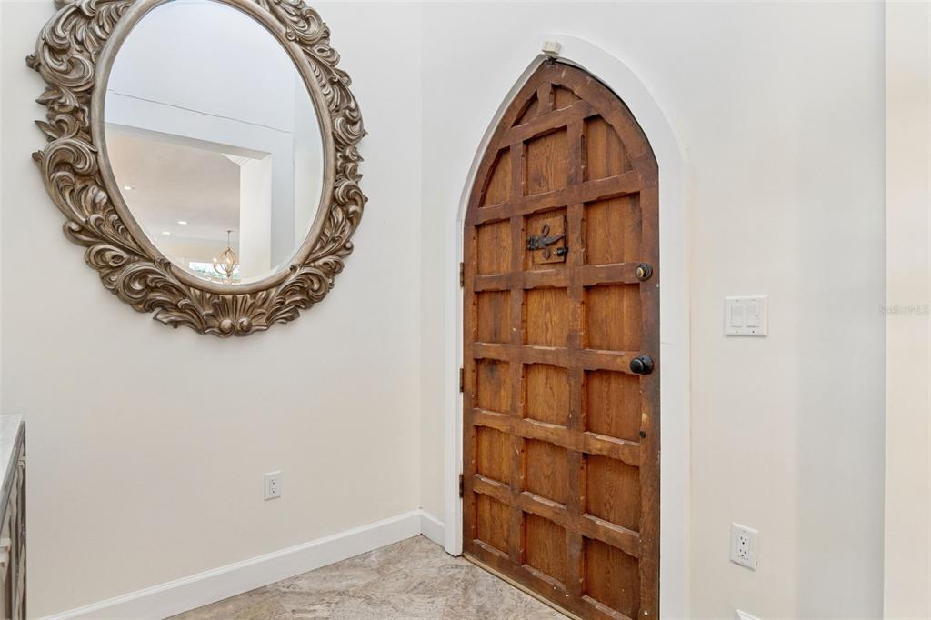 An entryway features a large ornate mirror and a wooden arched door with grid paneling — 1629 HEMPEL AVENUE, WINDERMERE, FL