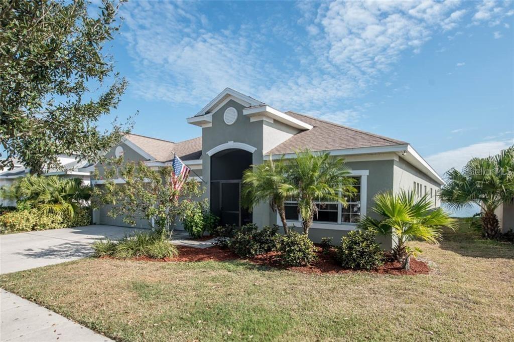 An aerial view of a suburban house with a garage facing a large lake — 1742 MIRA LAGO CIRCLE, RUSKIN, FL