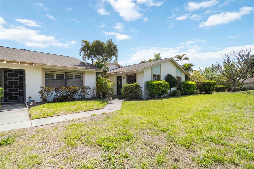 A paved walkway leads to a front door with a security gate and a bench — 6521 HERITAGE LANE UNIT 2621, BRADENTON, FL