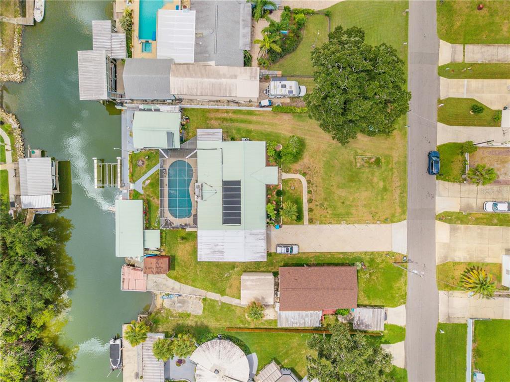 An aerial view of a waterfront house with a pool, dock, and large grassy yard — 215 GARY AVENUE, OAK HILL, FL