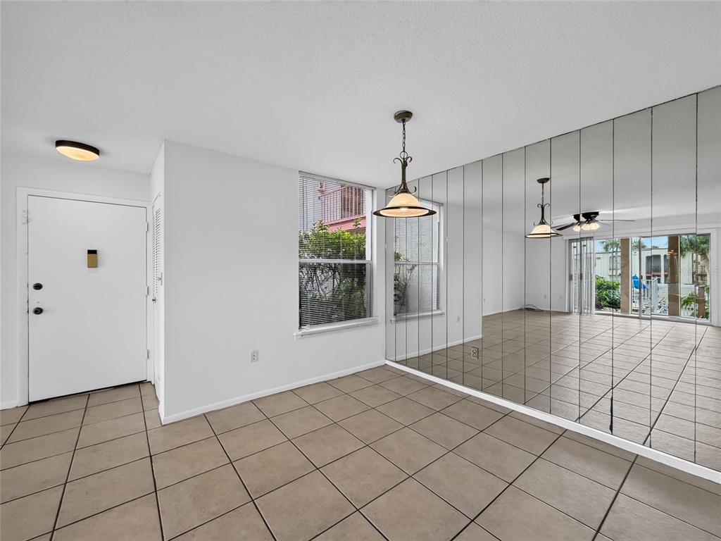 A dining area with tiled floors, a mirrored wall, and a window overlooking the outdoors — 518 ORANGE DRIVE UNIT 11, ALTAMONTE SPRINGS, FL