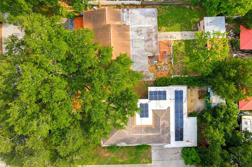 An aerial view shows two houses with large trees, solar panels, and a concrete driveway — 612 N WOODLYNNE AVENUE, TAMPA, FL