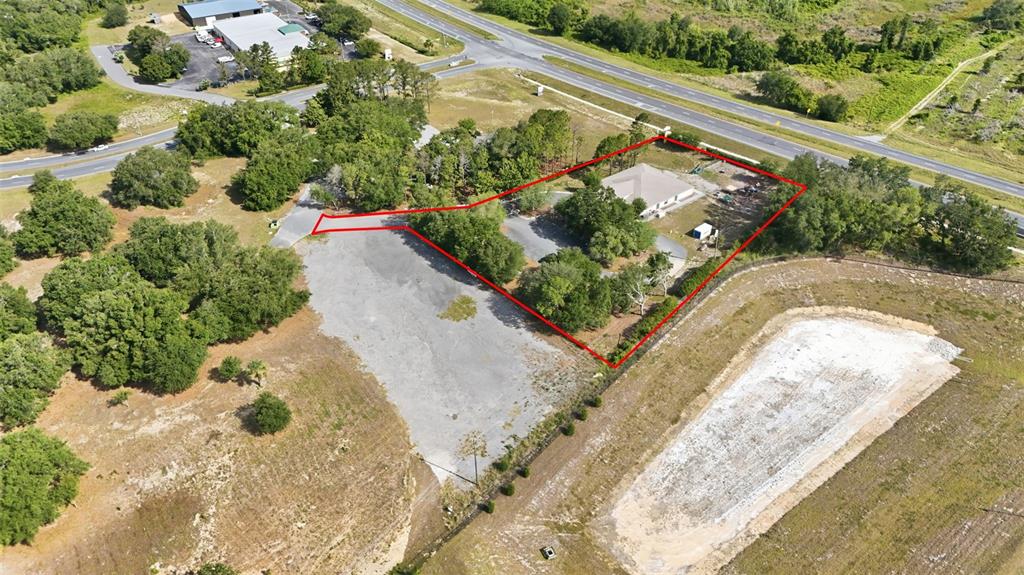 An aerial view shows a single-story building with a covered entrance and a fenced playground — 20540 INDEPENDENCE BOULEVARD, GROVELAND, FL