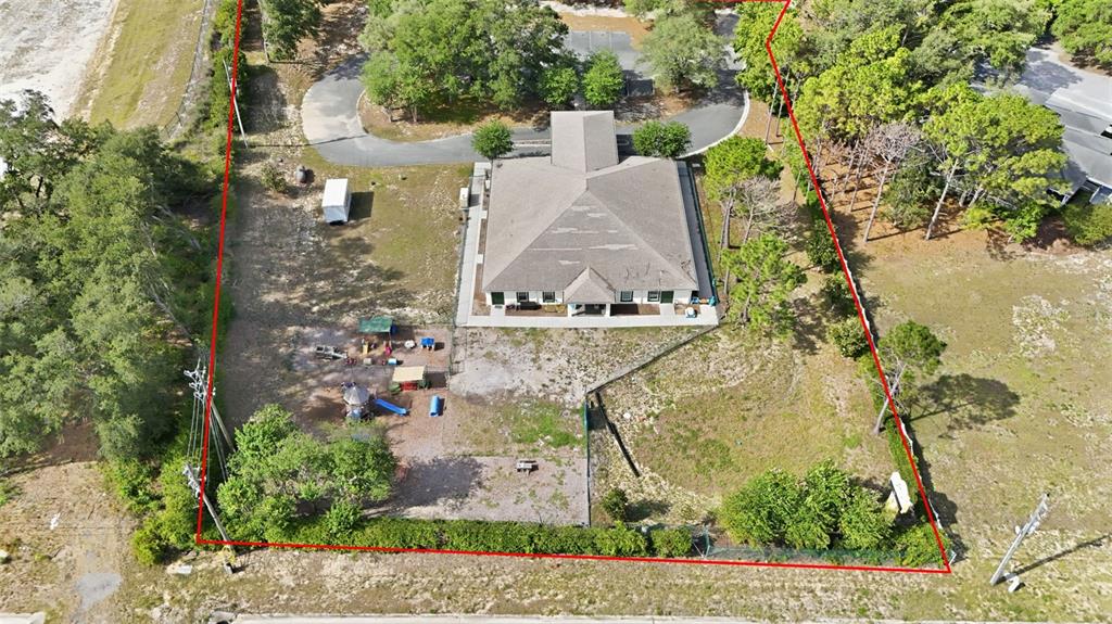 An aerial view shows a building with a covered entrance, playground, and a storage container — 20540 INDEPENDENCE BOULEVARD, GROVELAND, FL