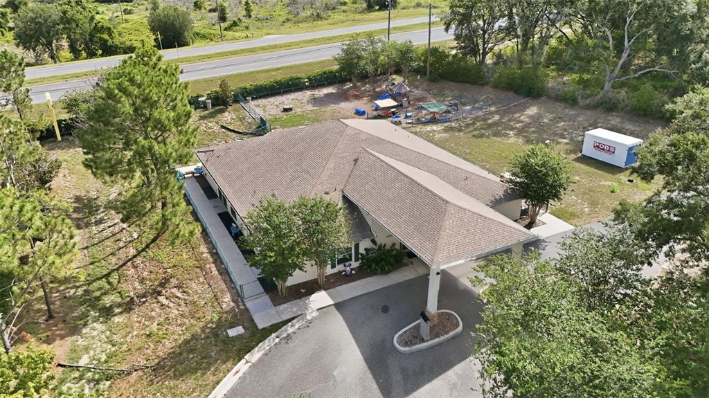 An aerial view shows a single-story building with a carport, playground, and storage container — 20540 INDEPENDENCE BOULEVARD, GROVELAND, FL