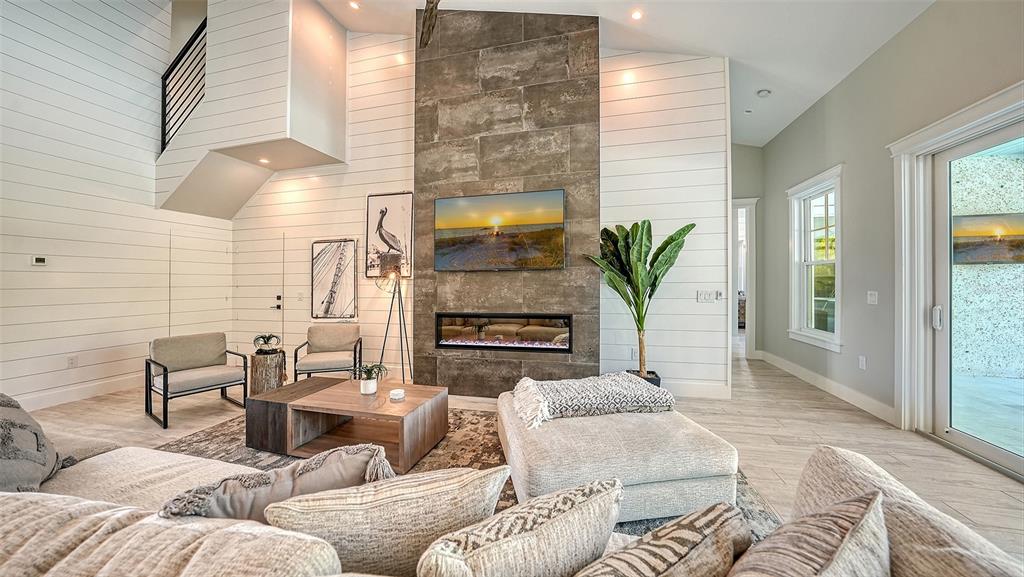 A living room features a tiled fireplace, shiplap walls, and a large sectional sofa — 8006 20TH PLACE W, BRADENTON, FL