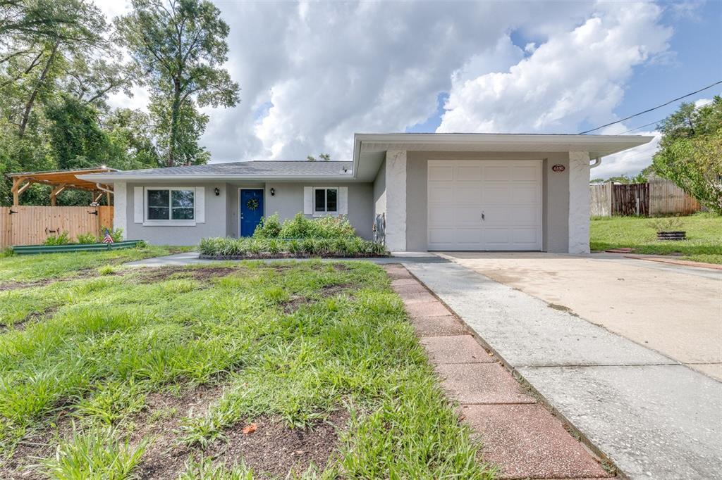 A single-story house with a gray exterior, blue front door, and an attached one-car garage — 6330 E VALE STREET, INVERNESS, FL