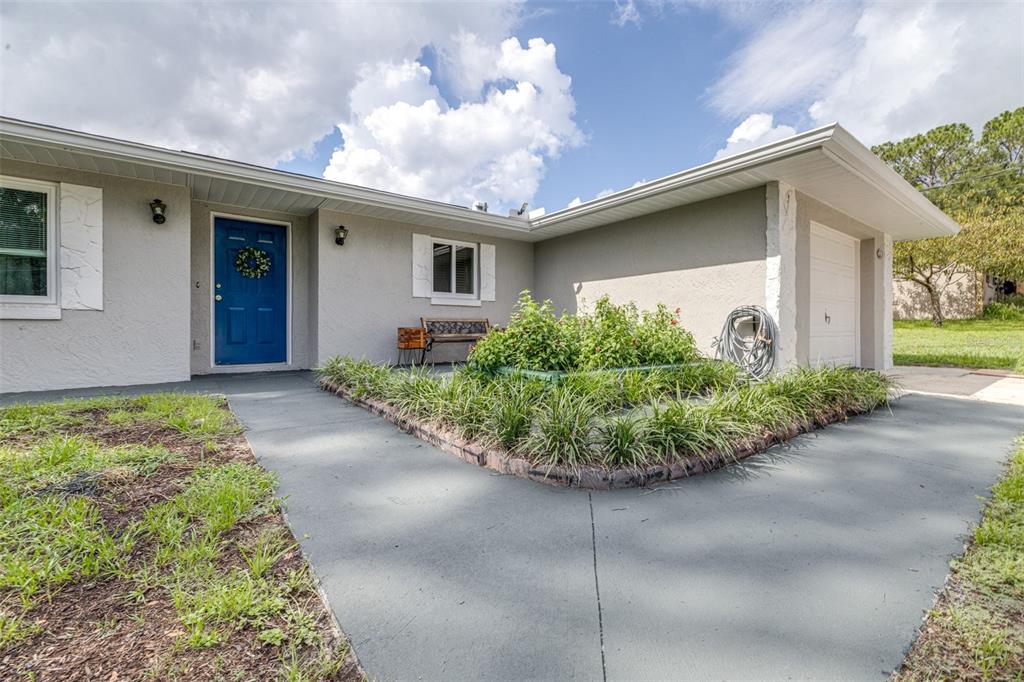 The exterior of a single-story house features a blue front door and a concrete walkway — 6330 E VALE STREET, INVERNESS, FL