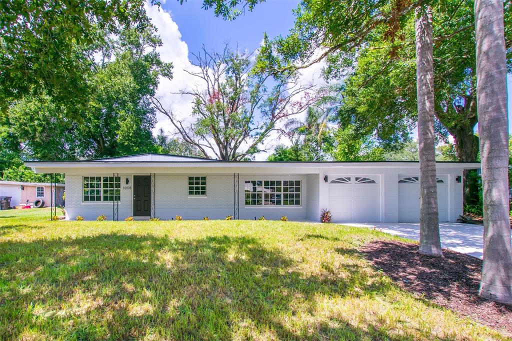 A single-story white brick house with a two-car garage and a large front lawn — 1008 BERWYN ROAD, ORLANDO, FL