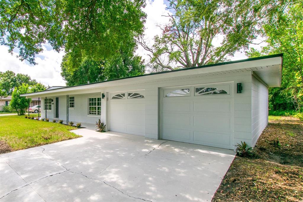 A single-story house with a white painted brick exterior and a two-car garage — 1008 BERWYN ROAD, ORLANDO, FL