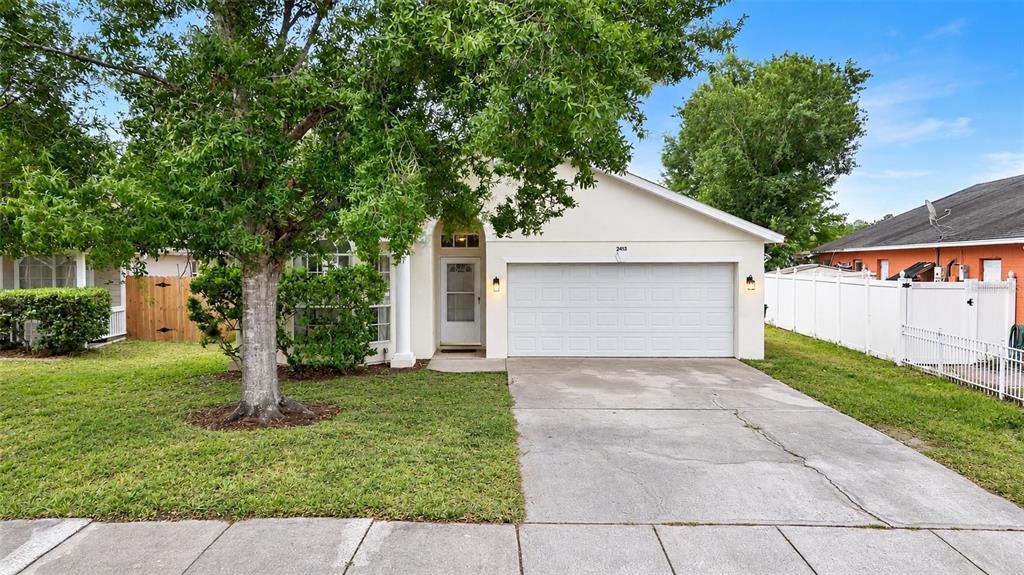 An aerial view shows a house with a brown roof situated between trees and water — 2413 RADNOR AVENUE, ORLANDO, FL