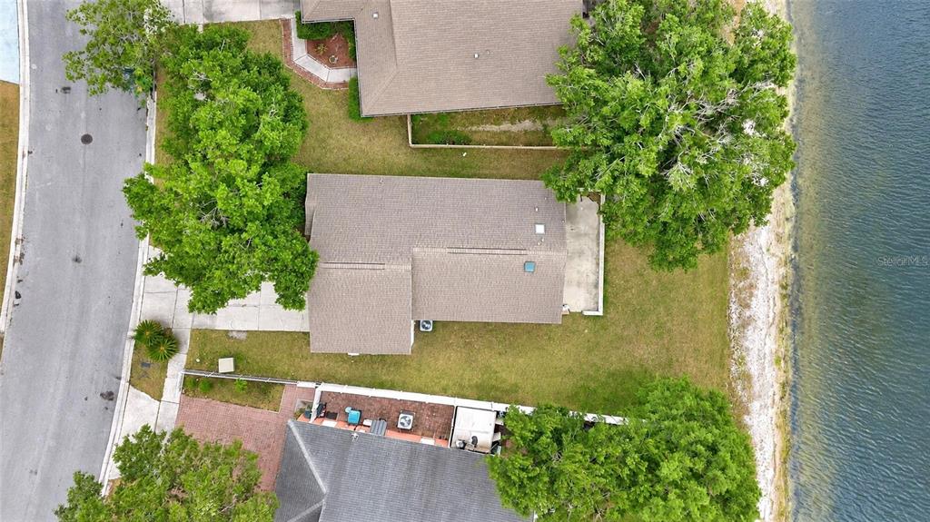A single-story house with a beige stucco exterior, a two-car garage, and a front tree — 2413 RADNOR AVENUE, ORLANDO, FL