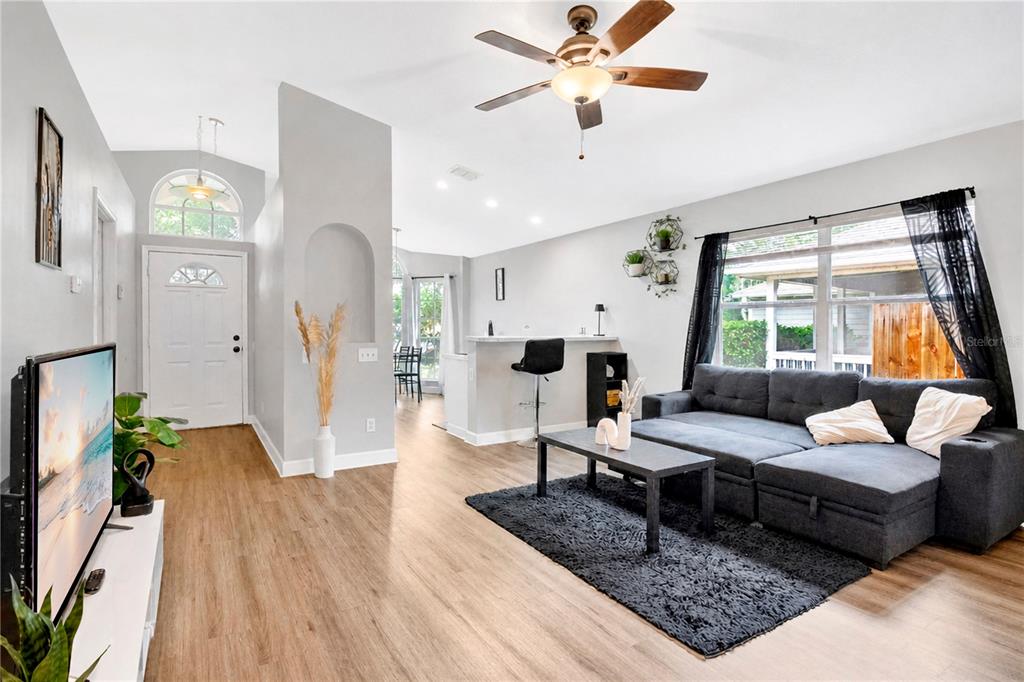 A single-story house with a tan exterior, a two-car garage, and a large front tree — 2413 RADNOR AVENUE, ORLANDO, FL