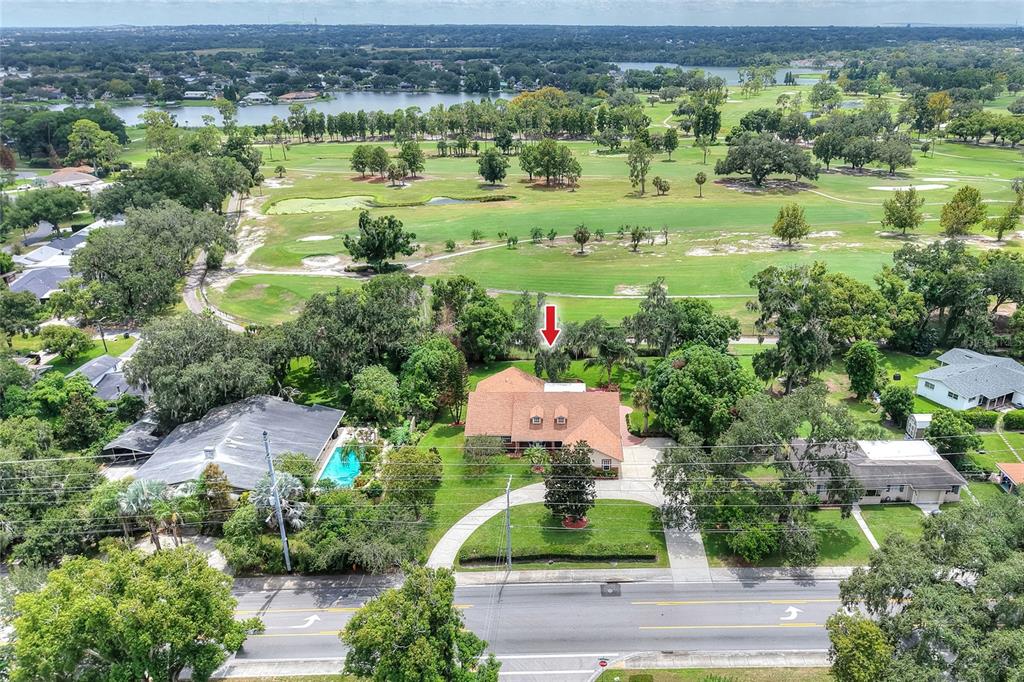 An aerial view shows a house with a brown roof situated near a golf course — 1221 E EDGEWOOD DRIVE, LAKELAND, FL