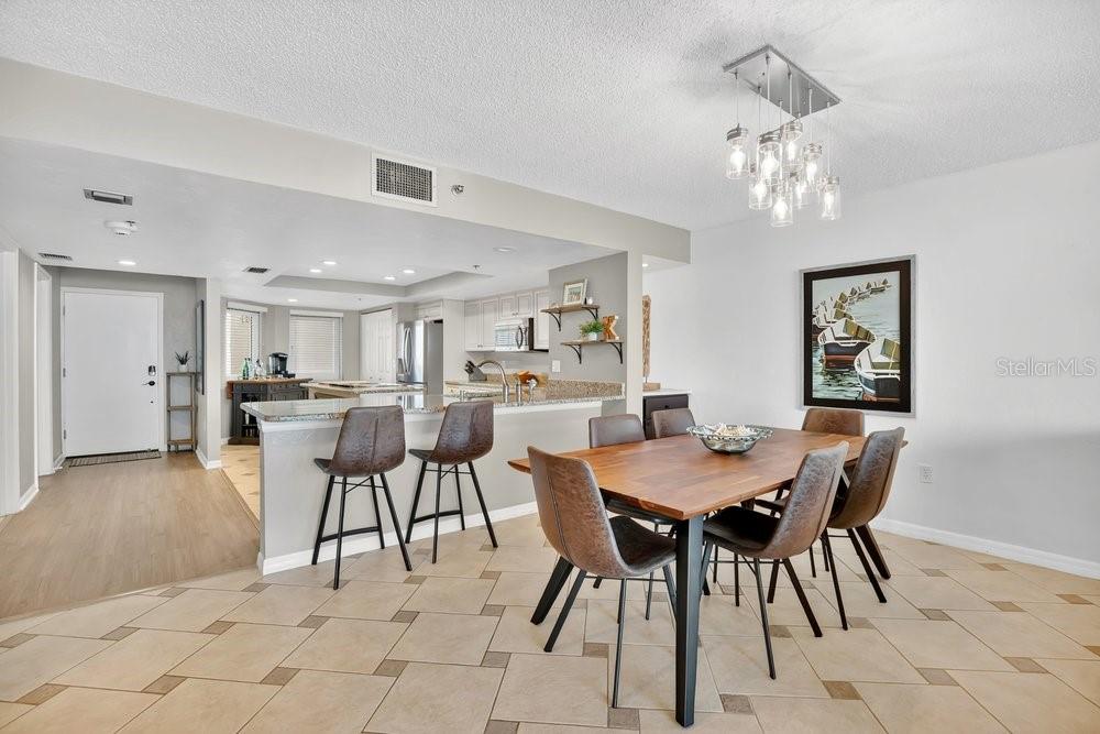 A living room with a gray sofa, glass coffee table, and a balcony overlooking the ocean — 257 MINORCA BEACH WAY UNIT 1005, NEW SMYRNA BEACH, FL