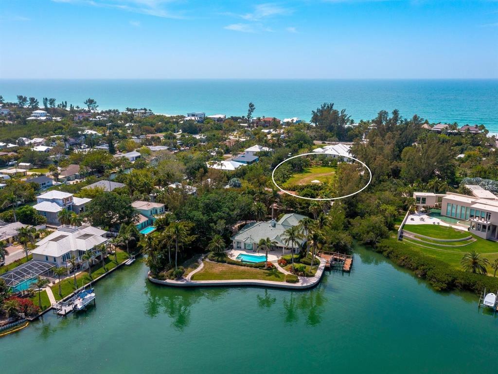 An aerial view shows a waterfront house with a pool and a large grassy lot — 6608 GULF OF MEXICO DRIVE, LONGBOAT KEY, FL