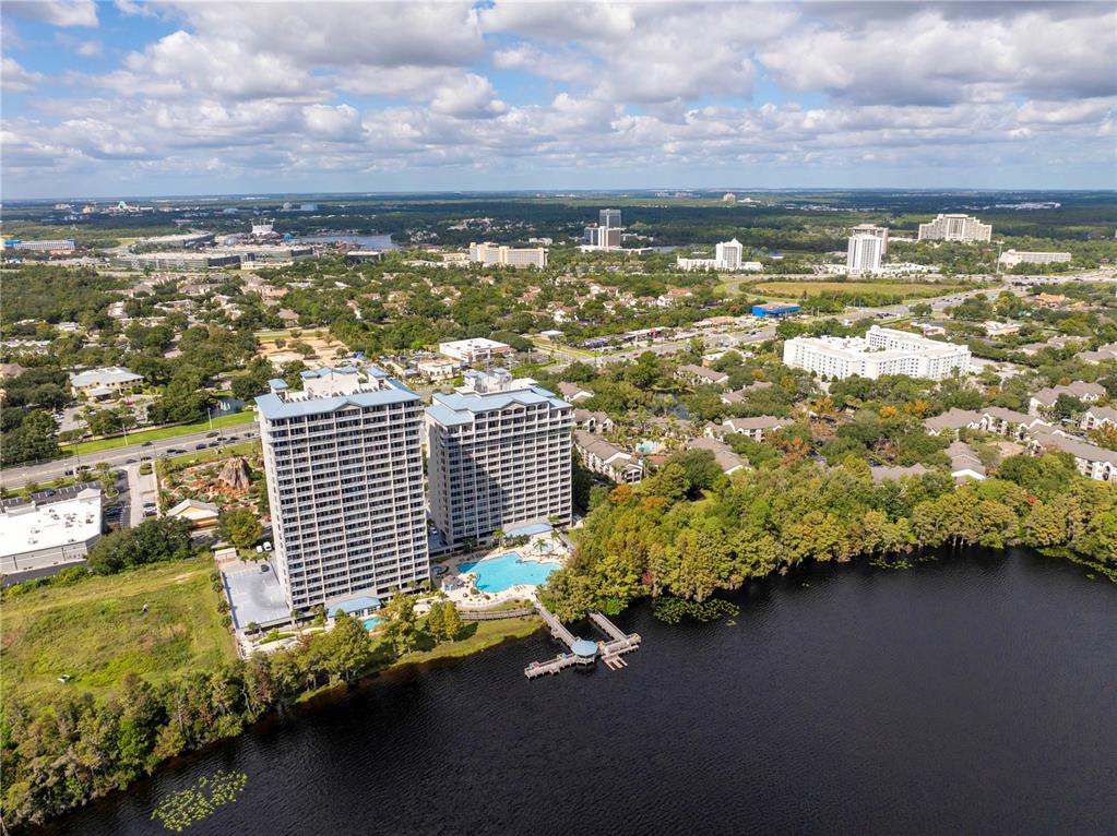 An aerial view shows two tall residential towers situated on the shore of a lake — 13415 BLUE HERON BEACH DRIVE UNIT 109, ORLANDO, FL