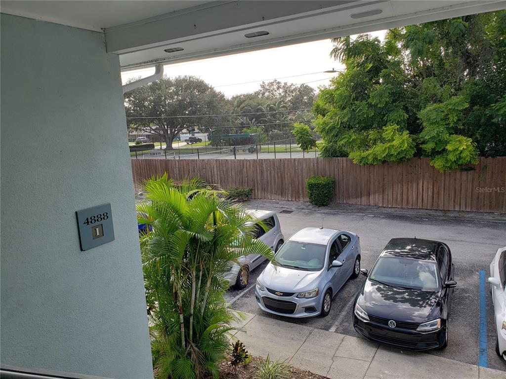 An elevated view shows a parking lot with three cars and a wooden fence — 4886 CONWAY ROAD UNIT 76, ORLANDO, FL