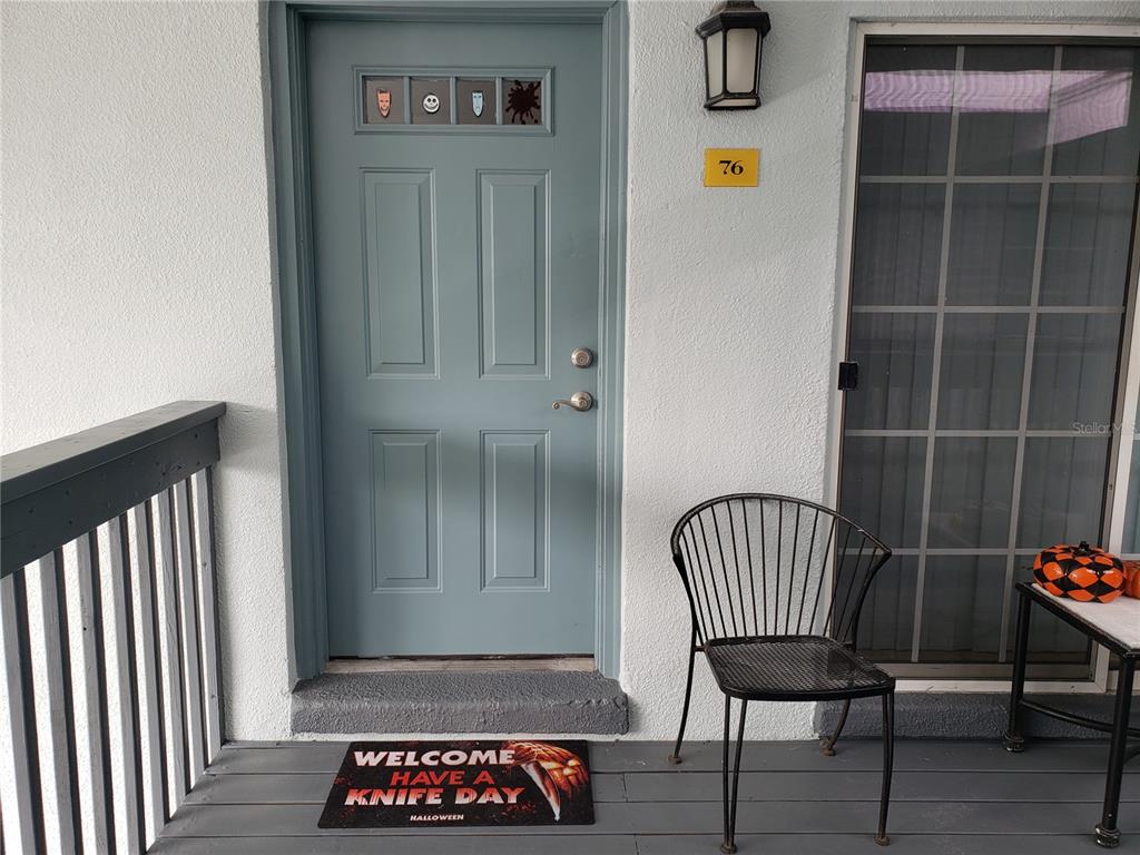 A blue front door with Halloween decorations and a themed doormat on a porch — 4886 CONWAY ROAD UNIT 76, ORLANDO, FL