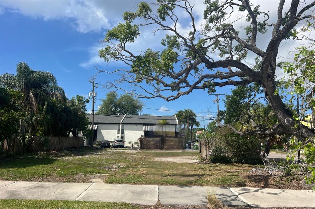 A vacant, grassy lot sits in front of a two-story white apartment building — 404 E DAVIS BOULEVARD, TAMPA, FL