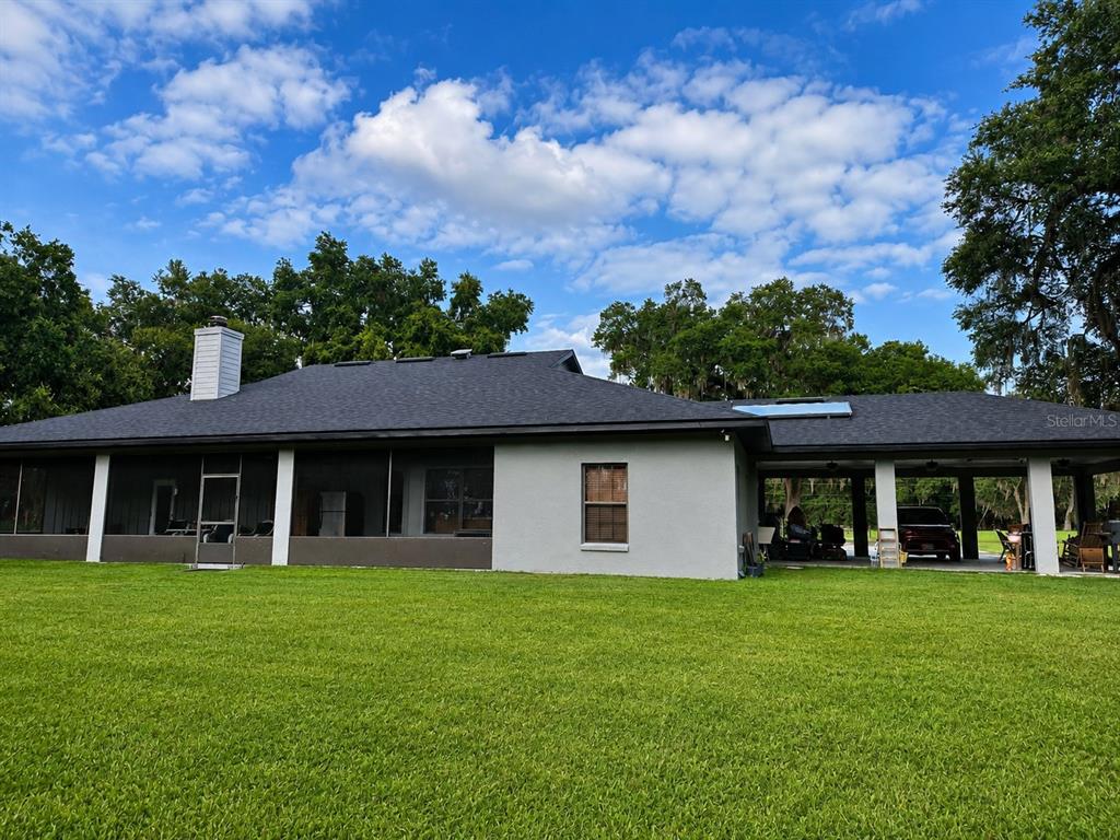 A living room features a stone fireplace, wood flooring, and double glass doors — 2672 SE 35TH STREET, SUMTERVILLE, FL