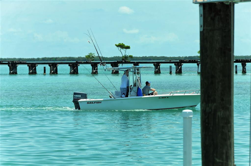 A white egret stands perched on a wooden piling against a clear blue sky — 6040 BOCA GRANDE CAUSEWAY UNIT 5, BOCA GRANDE, FL