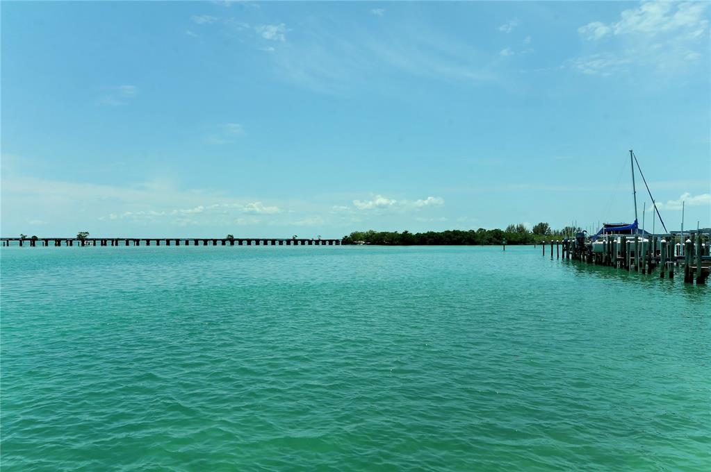 An aerial view shows a coastal bridge connecting islands surrounded by shallow turquoise water — 6040 BOCA GRANDE CAUSEWAY UNIT 5, BOCA GRANDE, FL