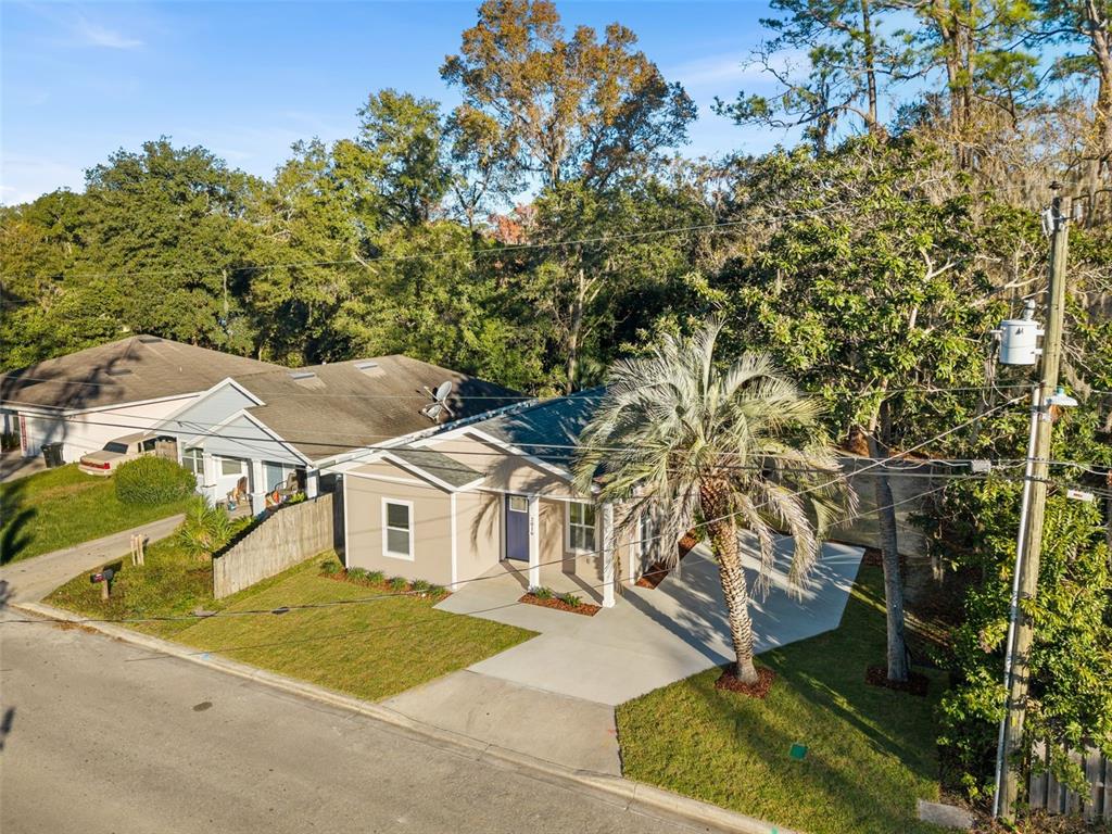 A single-story house with tan siding, a blue front door, and a covered porch — 2016 NE 3RD AVENUE, GAINESVILLE, FL