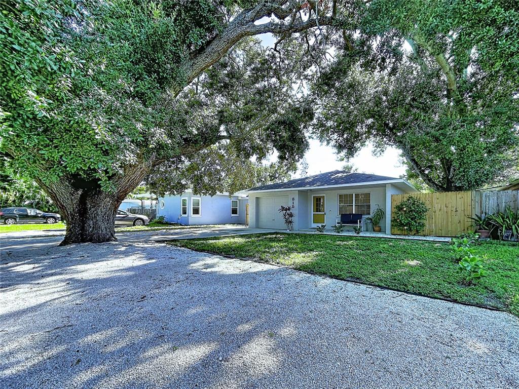 A single-story house with a gravel driveway and a large tree in the front yard — 815 35TH STREET W, BRADENTON, FL